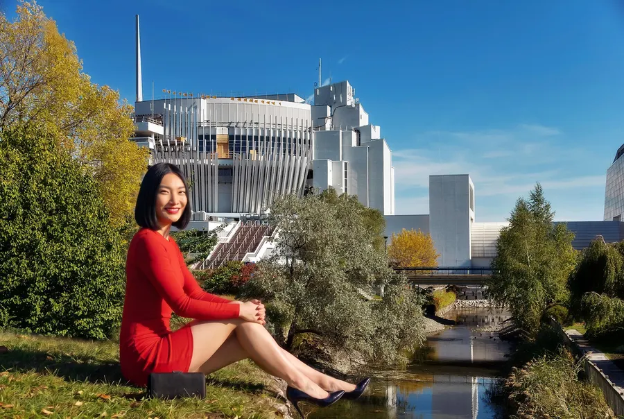 Une femme assise sur l’herbe au bord du canal, devant le casino